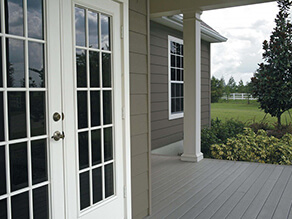 Brown Exterior Weatherboard with White Door Trims and Light Grey Support Beams and Garden and Porch